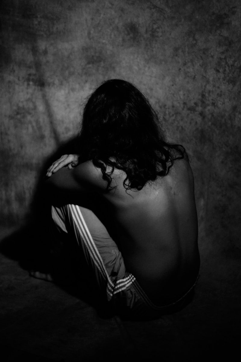 A person sitting on the ground with their back to the camera
